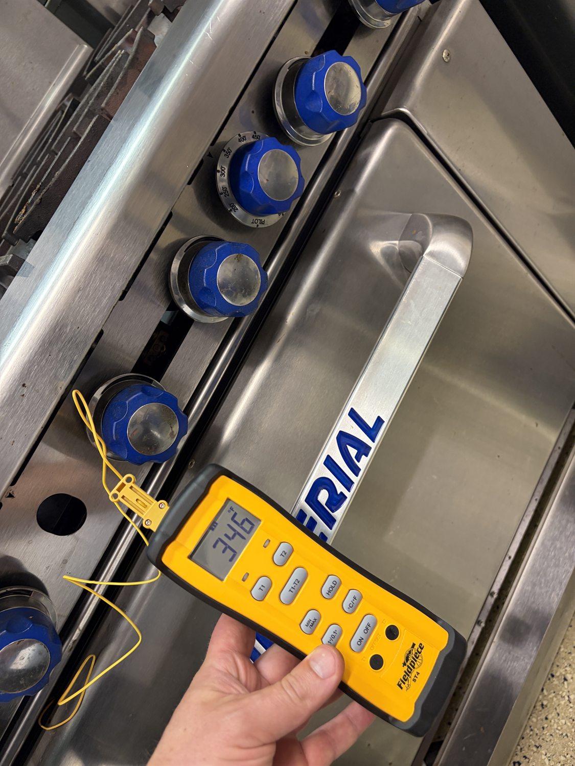 Checking burner temperature on a commercial range during a Philadelphia repair
