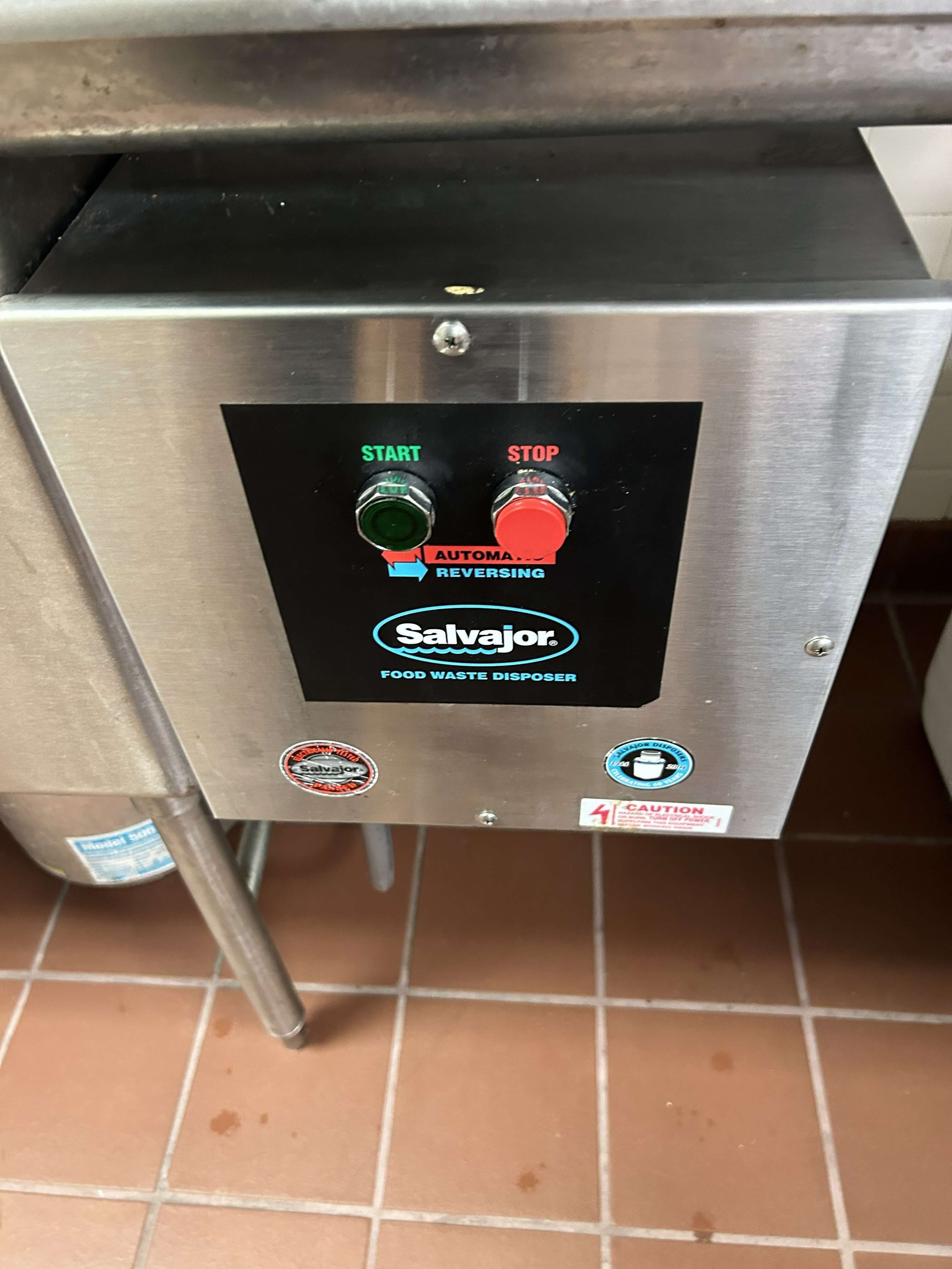 Commercial garbage disposal unit being repaired in Philadelphia kitchen